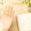 手のひらとノートで手相占いをやさしく学ぶイラスト